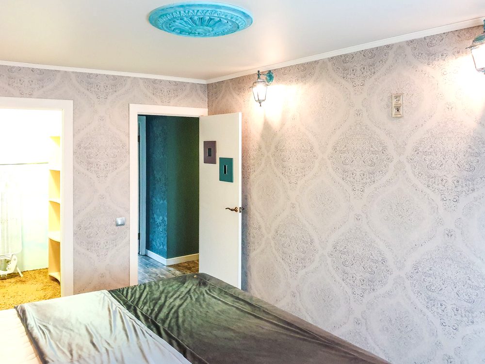 Bedroom with a soft damask wallpaper and a decorative ceiling detail
