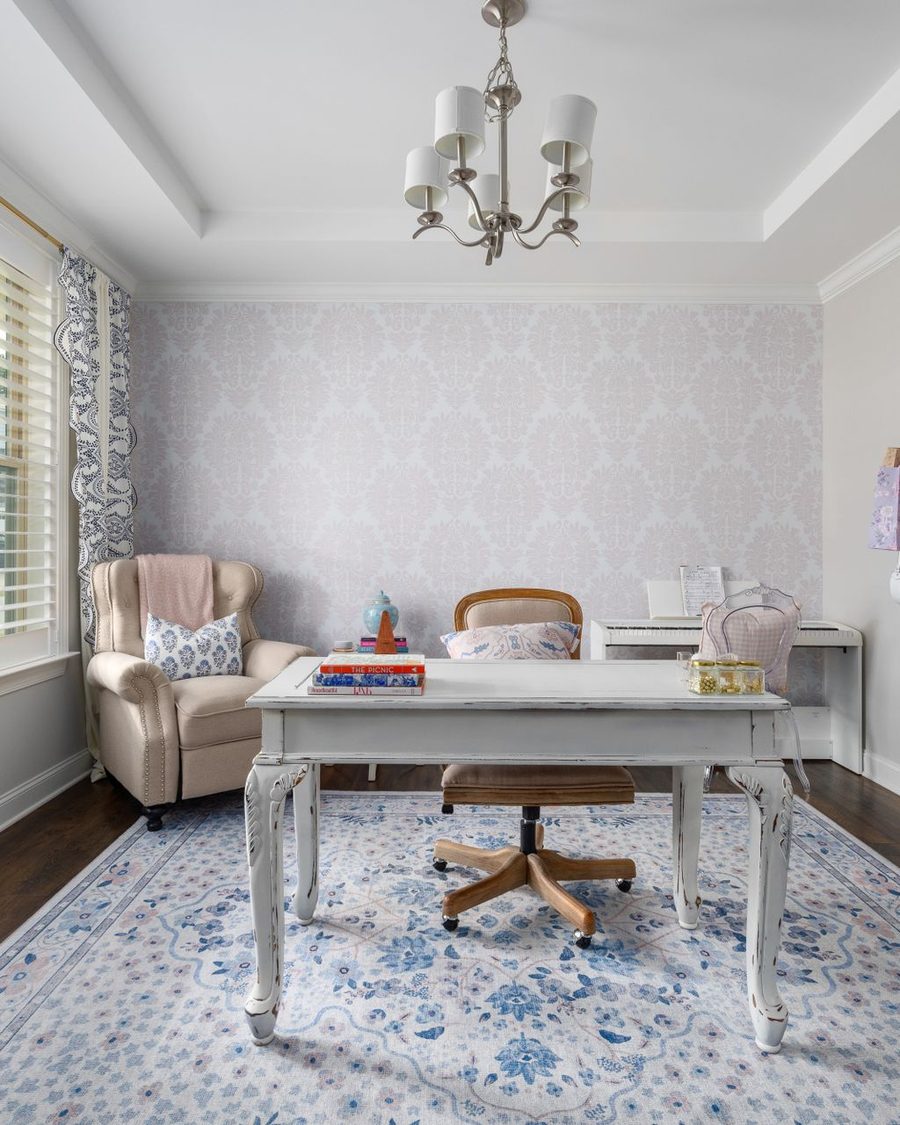 Home office with blue and white patterned wallpaper and an elegant writing desk