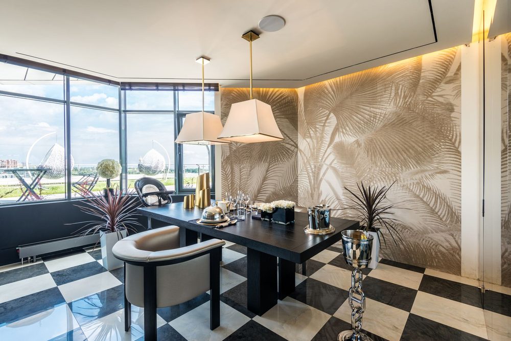 Elegant dining room with a tropical mural wallpaper and checkerboard floor