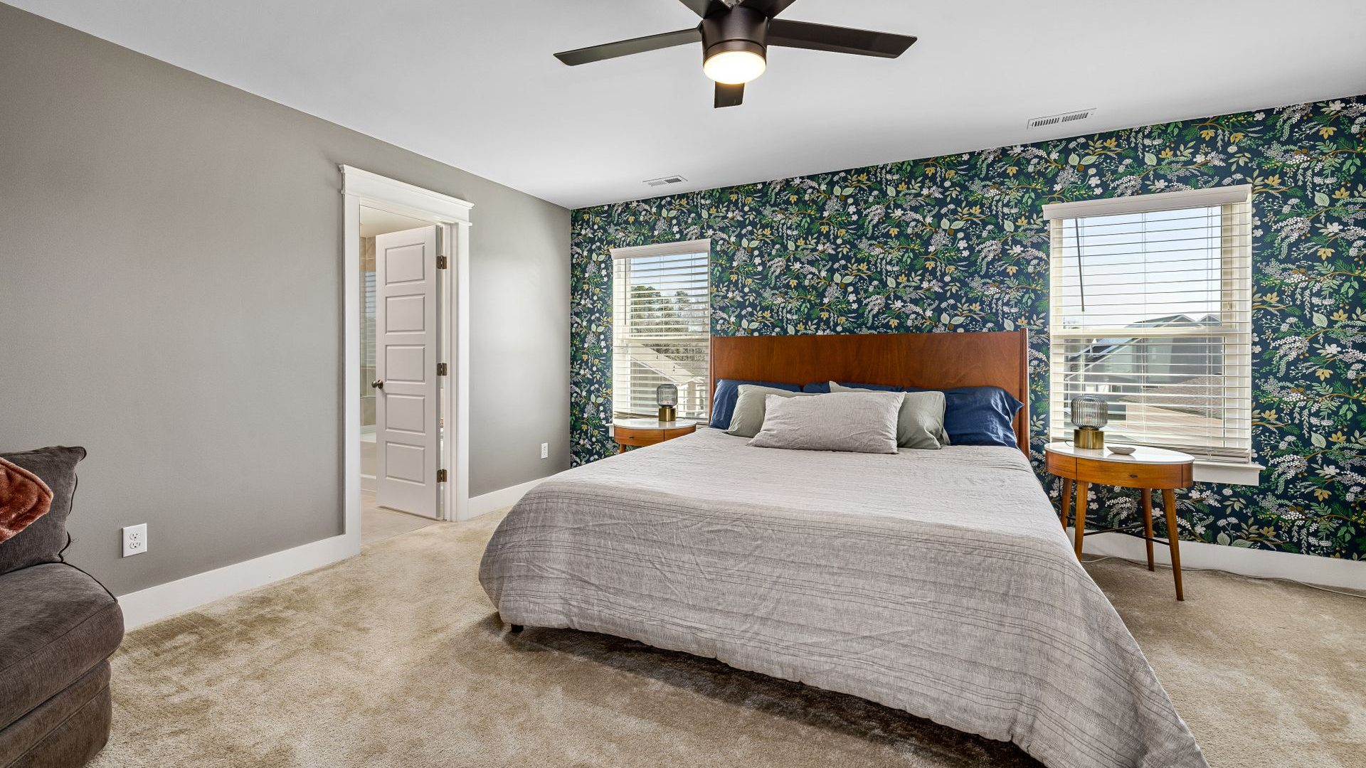 Bedroom with a botanical patterned wallpaper feature wall and neutral furnishings
